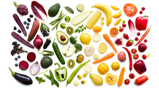 Different vegetables and fruits scattered around against a white background.