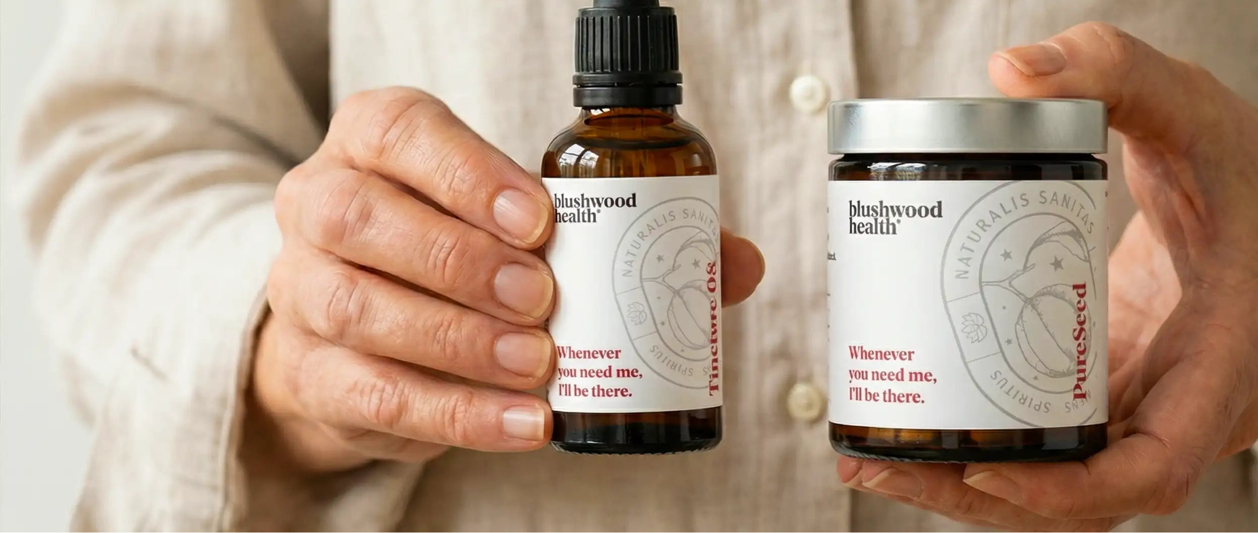 Person holding two bottles of a product with a neutral background